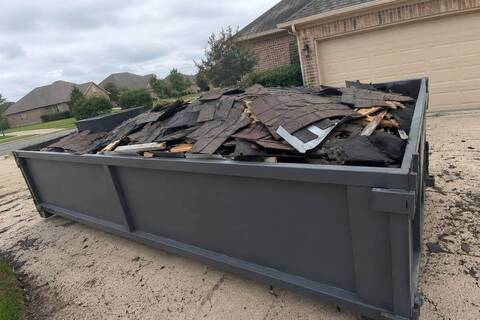 Dumpster loaded with roofing tear-off